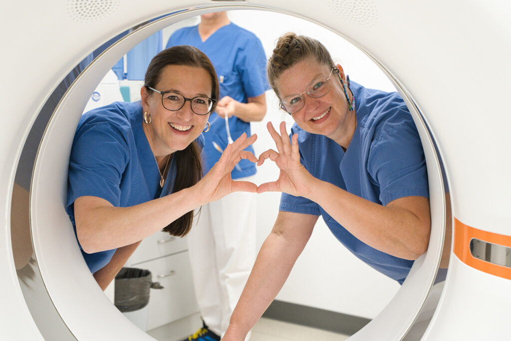 Das Bild zeigt Mitglieder des Teams der Radiologie des Onkologischen Zentrums, die mit den Fingern ein Herz formen.